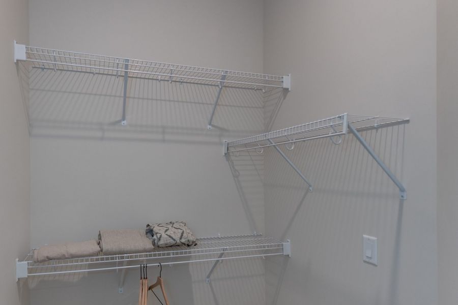 Acclaim at Greenbrier  apartment homes with Empty walk-in closet with carpet, wire shelves, folded blankets, and a few hangers on the lower shelf.
