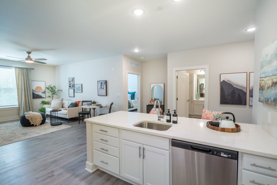 Acclaim at Greenbrier  apartment homes with Modern open-plan apartment with kitchen island, living area, and bedroom visible in the background.